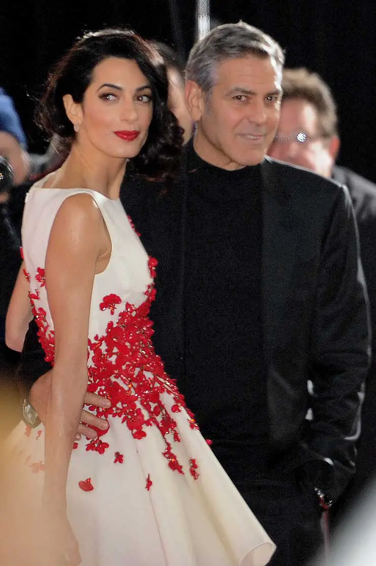 George Clooney looks on and laughs at wife Amal, as a gust of wind blows her dress up at the 'Hail Caesar' premiere in Los Angeles!