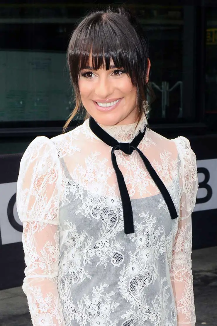 Lea Michele fashions a leggy see-through dress with silk tie and shows off a ring on her finger, UK