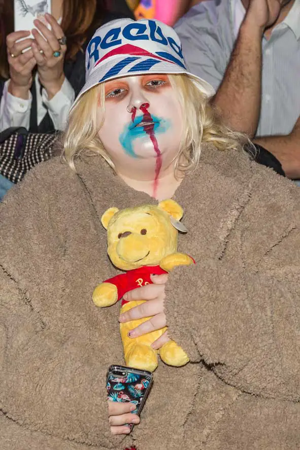 This outfit upstaged most of the runway models as this guest wore a vintage Reebok hat, a fur coat with blood running from her nose and holding Winnie the Pooh! Pictured at Mercedes Benz Fashion Week Madrid - Photo Courtesy of Image.net / Atlantic Images