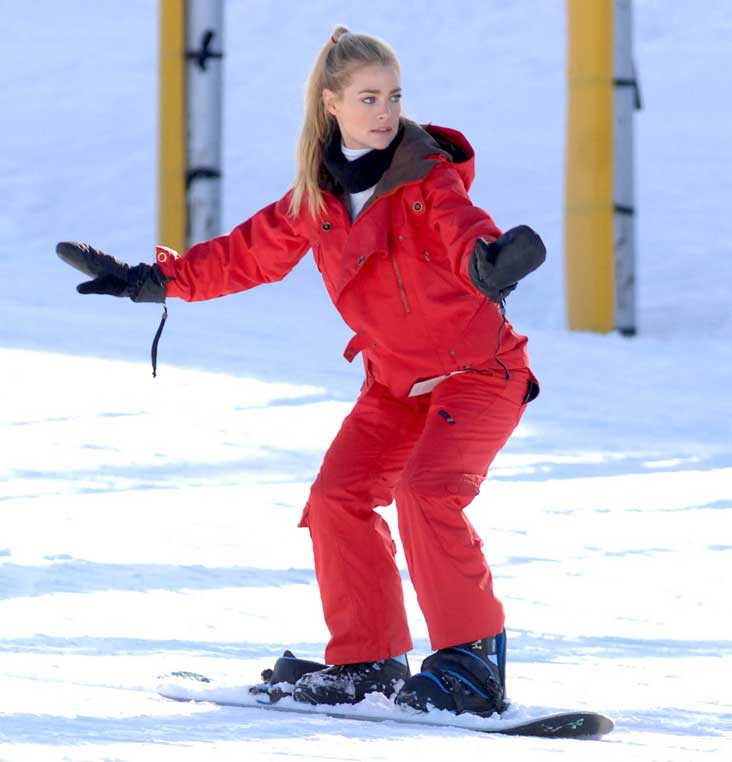 Denise Richards pictured snowboarding in Park City, Utah in a bright red ski outfit