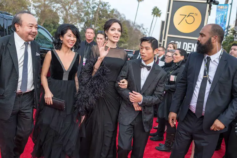 Angelina Jolie fashioned a black Atelier Versace black dress with Loung Ung and Pax Jolie-Pitt © HFPA