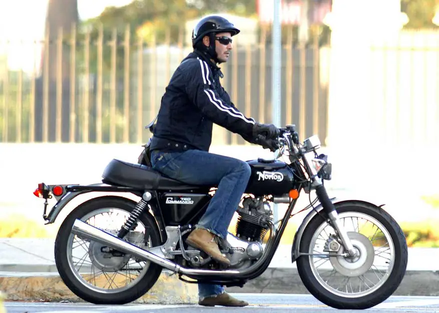 Keanu Reeves took his Norton 750 Commando for a spin around Los Angeles wearing a black helmet, matching black sunglasses, a striped jacket, jeans and boots