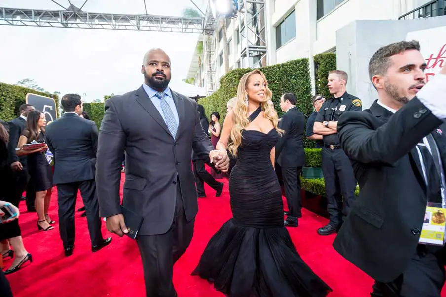 Mariah Carey was led by a bodyguard down the Golden Globe red carpet in a black Dolce & Gabbana gown © HFPA