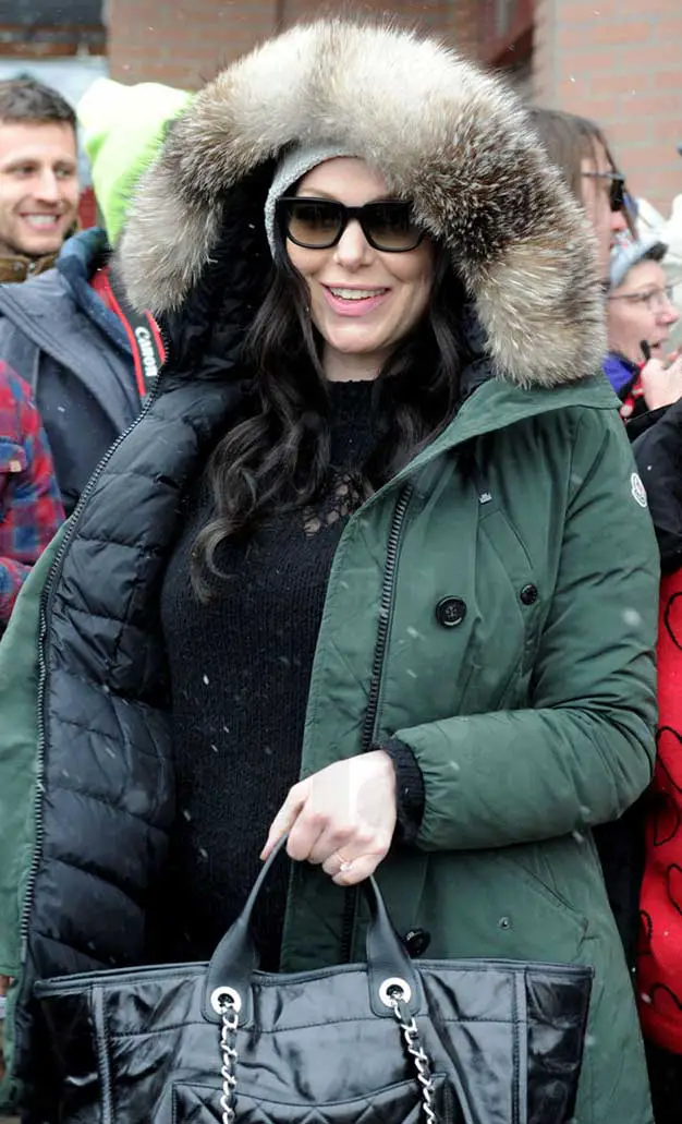 Laura Prepon fashion wearing a winter parka coat smiling in oversized sunglasses