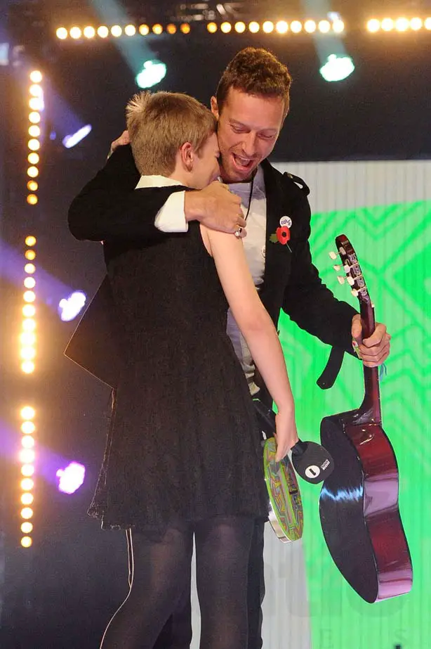 Chris Martin hugs Alice and give her a signed cartoon guitar at the Radio 1 Teen Awards in London