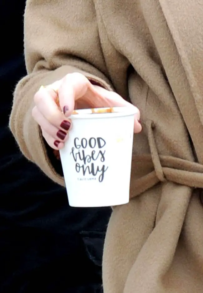 Naomi Watts stepped out in an unusual outfit but also promoted a positive message with her coffee cup reading “Good Vibes Only” Sorel Boot Trenchcoat 2018 sundance Film Festival promoting Ophelia Film