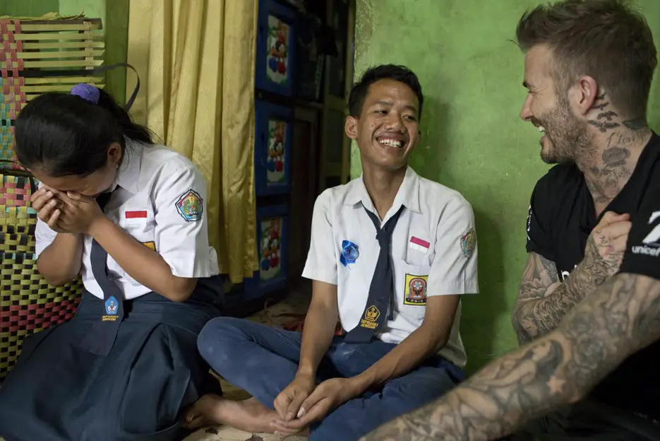 UNICEF Goodwill Ambassador David Beckham smiles with Sripun, 15 (left) and her friend Ego (centre) in his grandmother's home in Semarang, Indonesia - Photo Courtesy of UNICEF 7: The David Beckham UNICEF Fund
