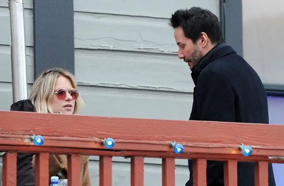 Keanu Reeves chats to a female friend on a balcony in Park City, Utah at the Sundance Film Festival
