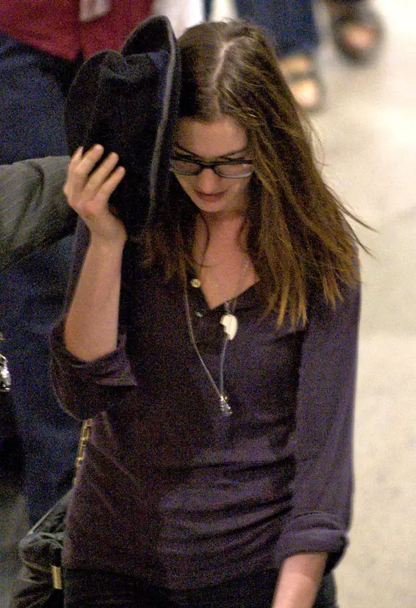 Anne Hathaway tried to hide from photographers with her hat over her face as she walked through LAX Airport © Atlantic Images