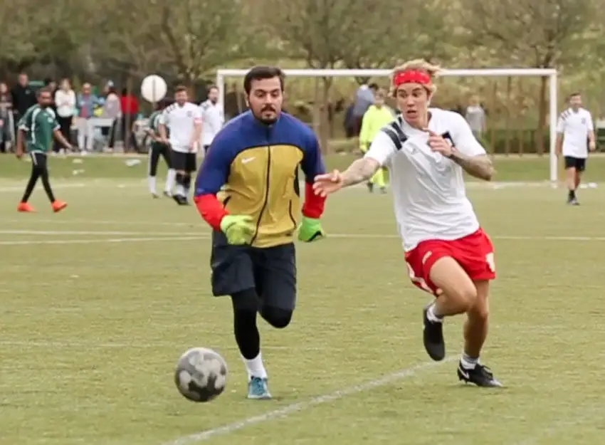 He's in! Justin Bieber races with the opposition goalkeeper trying to get past him! © The MEGA Agency