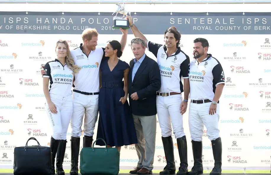 Champs! Meghan Markle presented husband Prince Harry with the winning trophy to support the Senteable charity - Photo courtesy of Image.net / Chris Jackson / Getty Images