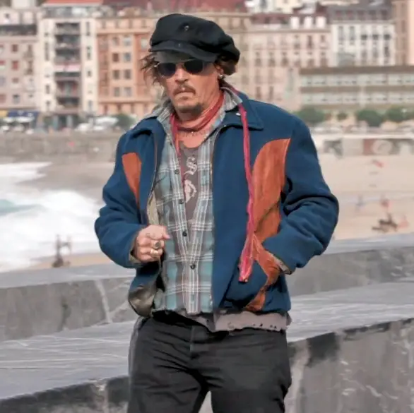 Johnny Depp throws something to a bystander and then celebrates after they catch it © The MEGA Agency