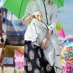 Gwen Stefani opted for an interesting beach look wearing a black patterned full length maxi skirt, a huge white shawl that kept blowing in her face and a bright green parasol that protected her from the sun © Atlantic Images Gwen Stefani Dog Megan Fashion Green Umbrella Beach Pomeranian Dog
